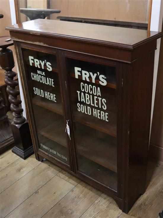 A late Victorian walnut two door bookcase, the doors later painted with the Frys chocolate logo W.92cm